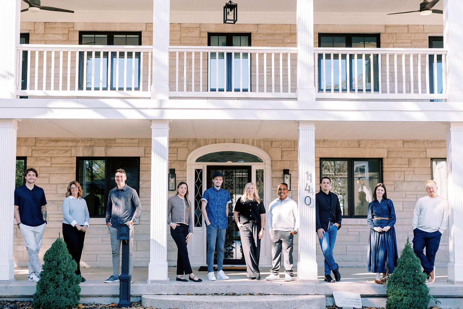 The Crest Point Real Estate team gathered on the front porch of the brokerage's Plainfield office at 140 North Center Street