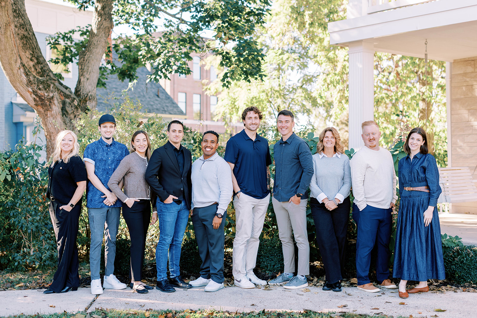 All fifteen Crest Point Real Estate agents standing together on a tree-lined downtown street in Hendricks County, Indiana